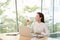 Photo of charming chinese businesswoman sitting at table and working with documents and laptop isolated