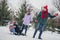 Photo of charming excited husband wife small kid wear windbreaker dragging sledges having fun together outside urban