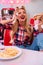 Photo of charming joyful woman eating hotdog and french fries