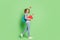 Photo of charming playful small schoolgirl dressed striped sweater rucksack walking throwing toy isolated green color