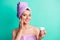 Photo of charming relaxed girl hold open balm jar palm cheekbone wear violet towel turban isolated teal color background