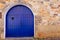 Photo of a charming stone building with a beautiful blue arched doorway