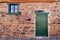 Photo of a charming stone building with a vibrant green door and window