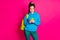 Photo of charming sweet young lady wear blue sweater rucksack looking modern device isolated bright pink color