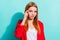 Photo of charming thoughtful orange hair lady wear red blazer finger temple smiling  cyan color background