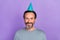 Photo of cheerful aged man have fun anniversary event birthday cap isolated over violet color background