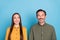 Photo of cheerful curious married man and woman look empty space up isolated on blue color background