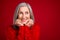 Photo of cheerful dreamy grandmother hands cheeks look empty space wear knitted pullover isolated red color background