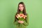 Photo of cheerful happy young nice lady hold hands bunch tulips spring  on green color background