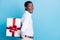 Photo of cheerful impressed dark skin guy dressed formal shirt hiding back gift box empty space smiling isolated blue