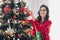 Photo of cheerful lady decorating christmas tree nice mood time improve atmosphere interior inside