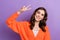 Photo of cheerful nice lady wear bright comfort outfit demonstrate v-sign hi symbol isolated on purple color background