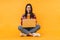 Photo of cheerful nice woman using laptop while sitting on floor