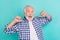 Photo of cheerful overjoyed grandfather showing his cool checkered shirt isolated on turquoise color background