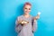 Photo of cheerful positive businesswoman wear grey sweater holding full plate chocolate sweet biscuits isolated on blue