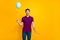 Photo of cheerful positive casual handsome man holding air ball of helium with hands wearing pants trousers blue