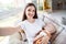 Photo of cheerful positive charming mother take selfie hold cuddle baby kid sleep wear white t-shirt home indoors