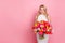 Photo of cheerful positive woman wear white dress getting flowers bunch empty space isolated pink color background