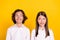 Photo of cheerful schoolkids look empty space think ideas wear white shirt isolated yellow color background