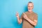 Photo of cheerful stylish pensioner pastel clothes two arm demonstrate empty space dentistry procedure isolated on blue