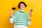 Photo of cheerful sweet lady wear striped pullover rising bank card shopping eshop isolated yellow color background