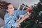 Photo of cheerful young happy woman hang toys christmas tree celebrate in living room house apartment flat