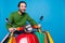 Photo of cheerful young male ride moped shopaholic look copyspace fast speed road isolated on blue color background