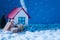 Photo of christmas banner small blue empty car standing snowy road near festive house windows giftboxes evergreen tree