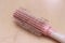 Photo close up top view hair fall at white pink plastick comb at wooden table