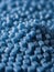 Photo Of Close Up Of A Two Stacks Of Blue Plastic Polypropylene Granules On A Table. Generative AI