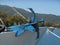 Photo of close up view to reddish and blue anchor standing on front part of fishing boat