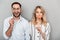 Photo closeup of joyful couple in casual clothing smiling and holding paper fake glasses and lips on stick