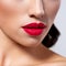 Photo of closeup of a part of a woman`s face. Lips of a beautiful girl with bright red lipstick. Macro image of the girl`s lips