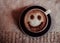 Photo of coffee cup of cappuccino on a saucer with print a smile on foam on a fabric napkin