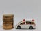 Photo of coins with miniature Ambulance isolated on white background.