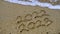 Photo of coming New Year 2023 and leaving year of 2022, Wrote text on sand at some beach with the small ocean wave.