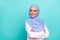 Photo of confident dreamy young lady dressed islamic hijab smiling arms crossed looking empty space isolated teal color