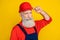 Photo of confident serious senior guy dressed uniform overall arm red hardhat isolated yellow color background