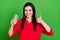 Photo of cool brunette millennial lady drink water show thumb up wear red shirt isolated on green color background
