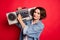 Photo of cool brunette young lady hold boom box wear jeans shirt isolated on red color background