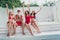 Photo of cool confident santa claus snow-maidens wear swimsuits sun bathing arms folded enjoying winter journey
