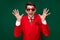 Photo of cool impressed santa claus guy dressed red jacket glasses rising arms isolated green color background