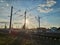 Photo of countryside with railway tracks, electric pillars against the background of the spring sky with clouds and the setting