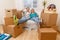 Photo of couple sitting on couch among cardboard boxes