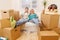 Photo of couple sitting on couch among cardboard boxes