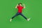 Photo of crazy active sporty guy jump celebrate victory wear red t-shirt jeans shoes isolated green color background