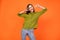 Photo of crazy brunette hairdo young lady show v-sign wear specatcles green shirt isolated on orange color background