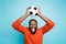 Photo of crazy excited mixed-race casual ecstatic black man raising soccer ball shouting with goal grimacing isolated