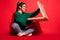 Photo of crazy hungry pretty young woman hold pizza box unhealthy food sit floor isolated on red color background