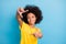 Photo of creative dark skin brunette girl make fingers frame wear yellow t-shirt  on blue color background